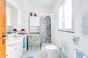 a white bathroom with a toilet and a sink at Casa Miriam in Oristano +16 photos