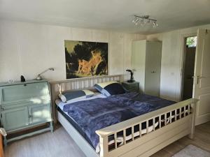 ein Schlafzimmer mit einem Bett und einem Gemälde an der Wand in der Unterkunft Ferienwohnung Unter Linden in Bad Bocklet