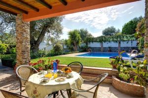 a table and chairs on a patio with a pool at Casa Buganvilla by Vintage Travel in Órgiva