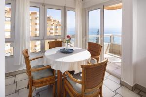 a table and chairs in a room with windows at Bloque 76 in Torrox