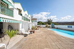 un complejo con piscina al lado de un edificio en Pomelo vacacional, en Arguineguín