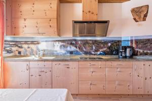 una cocina con fregadero y microondas en Wasserfall Moarlhof Kastelruth, en Castelrotto