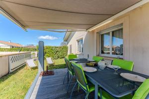 a patio with a table and chairs on a deck at La plage, les lacs et le calme in Biscarrosse