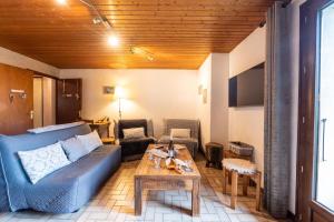 ラ・ジェッタにあるChalet Le Grand Nantの青いソファとテーブルのあるリビングルーム