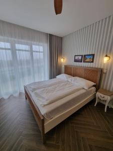 une chambre avec un grand lit avec des draps blancs dans l'établissement Ocean View Apartments, à Lourinhã