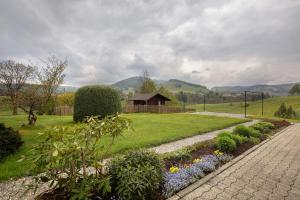 a garden with flowers and a building in the background at Ferienwohnung Karrach in Bernau im Schwarzwald