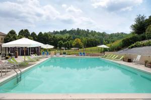 a large swimming pool with chairs and umbrellas at Golf Resort Il Feudo Apt 29 in Asti