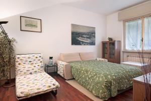 une chambre avec un lit et une chaise dans l'établissement Casa Rizzo - ac and free parking, à Rapallo