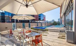 a patio with tables and chairs and a pool at City Lodge Newtown, Johannesburg in Johannesburg