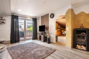 een woonkamer met een open haard en een televisie bij Auenwald in Roding