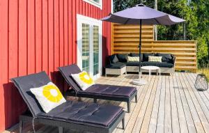 a patio with two chairs and an umbrella at Awesome Home In Ingarö With Ethernet Internet in Forsvik