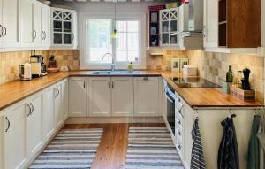a kitchen with white cabinets and a sink at Awesome Home In Ingarö With Ethernet Internet in Forsvik