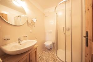 a bathroom with a sink and a shower and a toilet at Kofler zw den Wänden Apt Enzian in Campo Tures