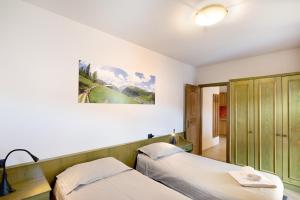 une chambre avec deux lits et un tableau au mur dans l'établissement Casa Marcos n 31, à Livigno