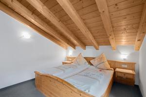a wooden bed in a room with a wooden ceiling at Petrushof Ferienwohnung Rechenberg in Oberwössen