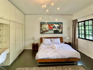 une chambre avec un lit et un lustre dans l'établissement Cozy Family Homestay 2BR with Balcony in Shared Bungalow SS2 PJ, à Petaling Jaya