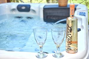 two glasses and a bottle of wine in a tub at Doliva Studio Anthi private jacuzzi in Agios Gordios
