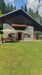 a stone building with a bench in front of it at Baita casapendola in Marter di Roncegno