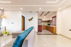 a living room with a couch and a kitchen at The Garden Retreat by StayJadePool2BHKLawn in Berikai