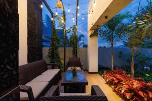 a patio with a couch and a coffee table at The Garden Retreat by StayJadePool2BHKLawn in Berikai