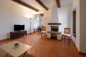 a living room with a television and a fireplace at Ginepro Poderone in Grosseto