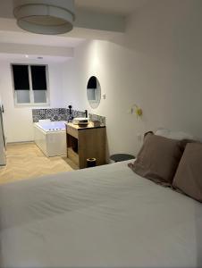 ein Schlafzimmer mit einem Bett und ein Badezimmer mit einer Badewanne in der Unterkunft SPA & Détente - Cocon romantique au coeur de Moulins in Moulins