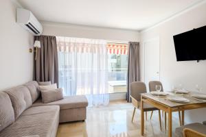 a living room with a couch and a table at appart terrasse 1 mn de la plage in Nice