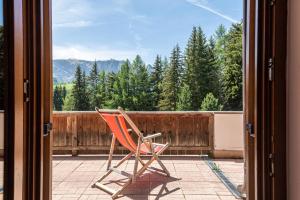 einen Stuhl auf einer Veranda mit Blick auf ein Fenster in der Unterkunft Ferienparadies Sabina Joch in Alpe di Siusi