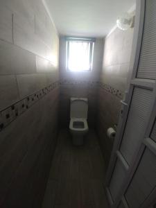a small bathroom with a toilet and a window at 220 Mclarty in Durban