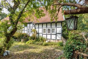 una casa bianca e nera con un albero di Wie Bei Muddi a Lübbecke