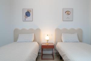 a room with two beds and a table with a lamp at Iberos Home in Seville