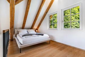 a room with a bed and two windows at Die Alte Mühle Am Hanselishof in Schenkenzell