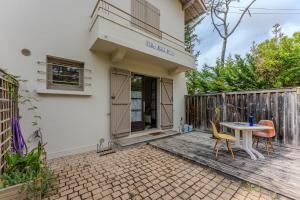 a house with a table and chairs on a patio at Cap Ferret Phare - Réf 0107 in Lège-Cap-Ferret