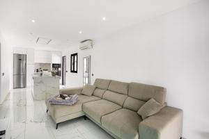 a living room with a couch and a kitchen at Sunset House Maspalomas in Playa del Ingles