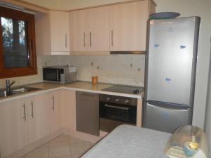 a kitchen with white cabinets and a stainless steel refrigerator at Studio Foris in Syvota +10 photos