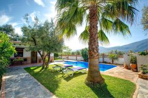 オルヒバにあるCasa Encantadora by Vintage Travelのヤシの木とスイミングプールのある裏庭