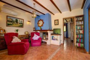 オルヒバにあるCasa Encantadora by Vintage Travelのリビングルーム(赤い椅子2脚、暖炉付)