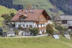 a house with a roof on a hill at Haus Belodei - Apt A in San Martino in Badia +13 photos
