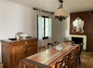een eetkamer met een houten tafel en stoelen bij Cap Ferret Océan - Réf 52 in Lège-Cap-Ferret