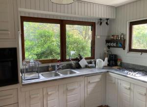 een keuken met twee wastafels en twee ramen bij Cap Ferret Océan - Réf 52 in Lège-Cap-Ferret +12 foto's