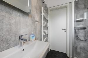 a white bathroom with a sink and a shower at Ferienwohnung Eggers in Cuxhaven +19 photos