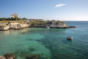 two boats in the water near a small island at Villa Scoglio in Melendugno +14 photos