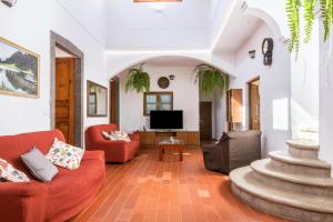 a living room with two red chairs and a television at El Huerto in Firgas