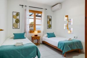 Un dormitorio con dos camas y una ventana en Villa Fernando, en Playa Blanca 19 fotos más