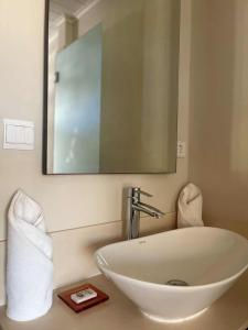 a bathroom with a white sink and a mirror at Residence Alizees Spa in Mauritius