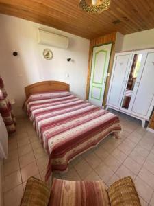 a large bed in a room with two chairs at Gite Saint Guiral en pleine nature in Dourbies