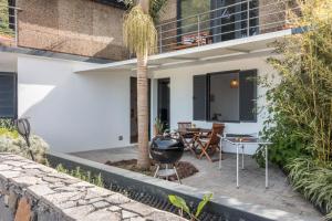 eine Terrasse mit Grill neben einem Haus in der Unterkunft Palmeira House - Fernandes Cottage in Ponta Delgada