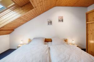 2 Betten in einem Schlafzimmer im Dachgeschoss mit Holzdecken in der Unterkunft Haus Thomann in Höchenschwand