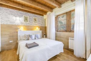 a bedroom with a white bed and a brick wall at Moli in Oden