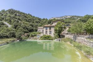 a large pool of green water in front of a building at Panoramico in Oden
